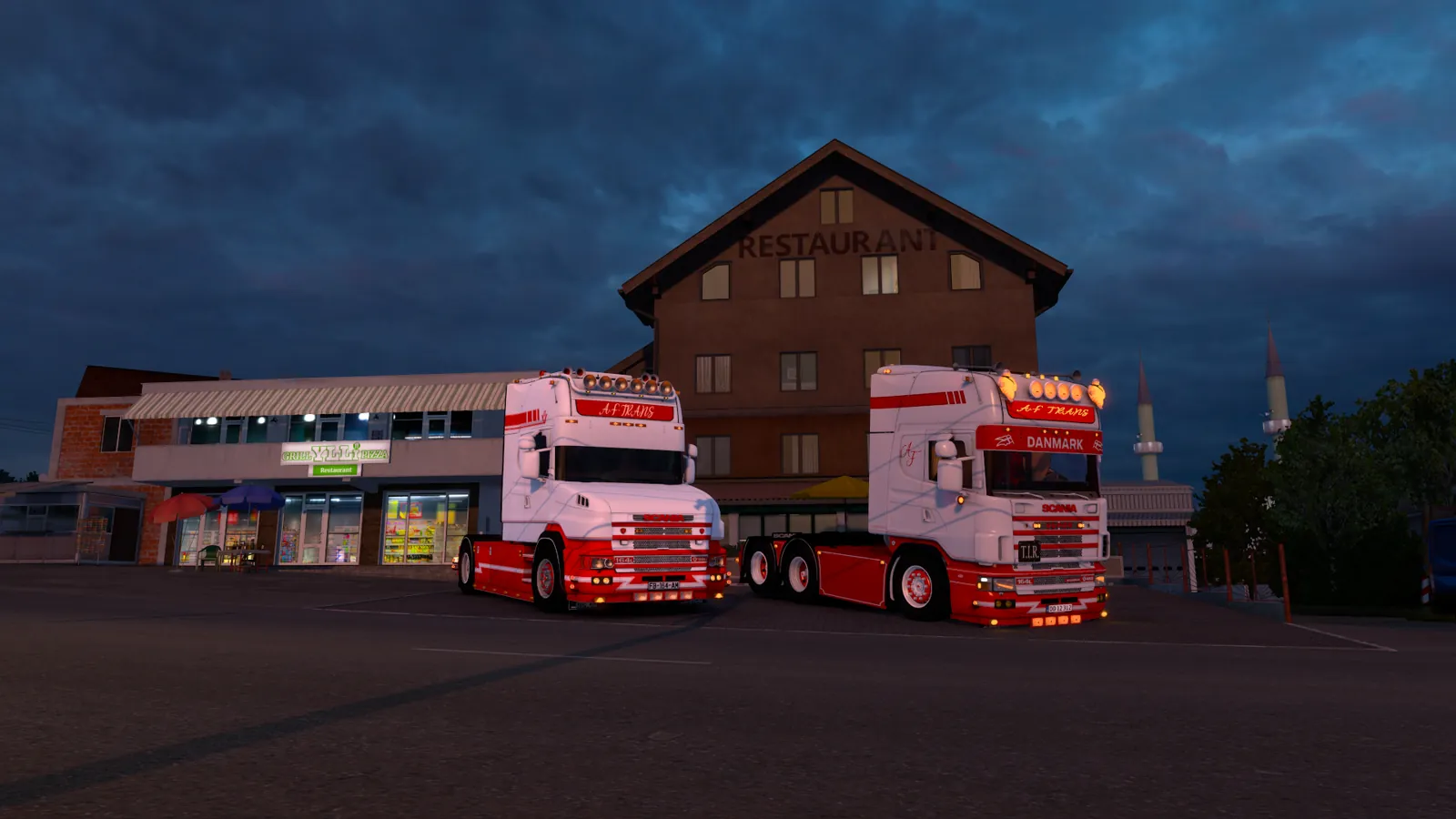 Deux Scania 164L AF Trans garés devant un restaurant routier, au crépuscule